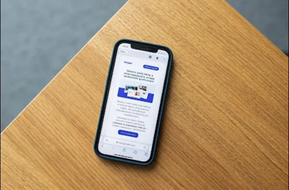 Smartphone posé sur une table en bois affichant un site web WordPress optimisé pour mobile développé par l'agence.